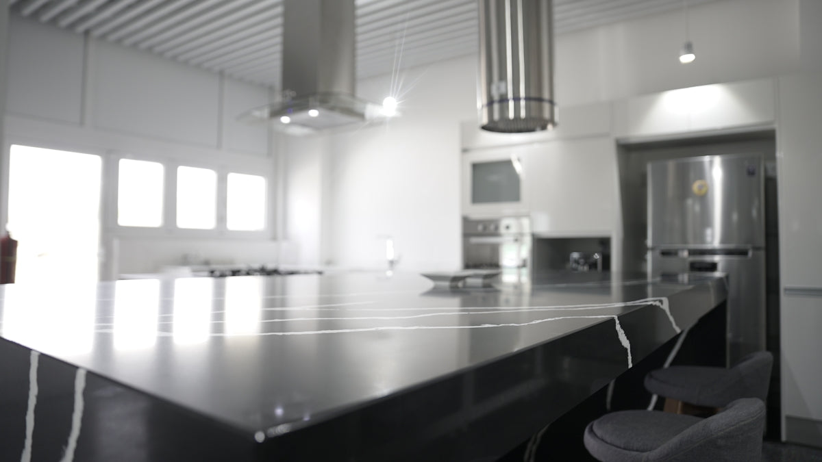 a kitchen with a large counter top and chairs