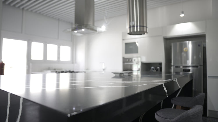 a kitchen with a large counter top and chairs